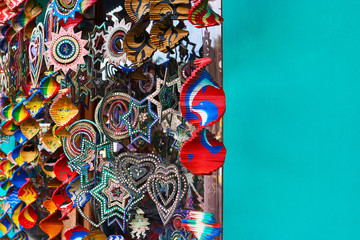 Various objects displayed in an souvenirs shop. Colorful souvenir background. Collection of colorful wooden different things in the market. Stars, hearts and fans decorated. Selective focus.