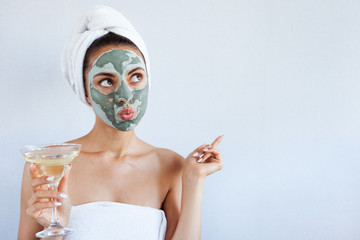 Young beautiful woman in face mask of therapeutic blue mud. Spa treatment, self care and healthy skin - 218041559