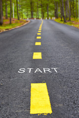 Words of start with yellow line marking on road surface in the park, transportation concept and...
