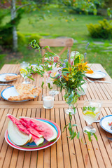 Family outdoor dinner in the garden in summer at sunset. Picnic food and drink concept