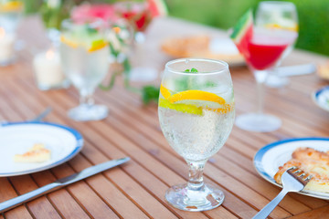Family outdoor dinner in the garden in summer at sunset. Picnic food and drink concept