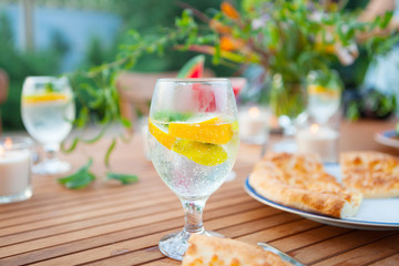 Family outdoor dinner in the garden in summer at sunset. Picnic food and drink concept