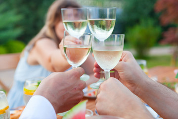 Family outdoor dinner in the garden in summer at sunset. Picnic food and drink concept