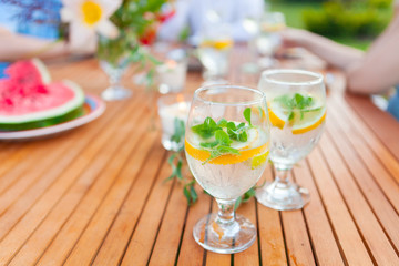 Family outdoor dinner in the garden in summer at sunset. Picnic food and drink concept