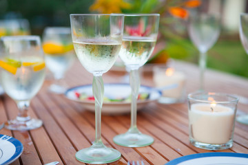 Family outdoor dinner in the garden in summer at sunset. Picnic food and drink concept