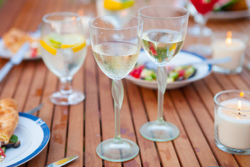 Family outdoor dinner in the garden in summer at sunset. Picnic food and drink concept