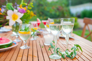 Family outdoor dinner in the garden in summer at sunset. Picnic food and drink concept