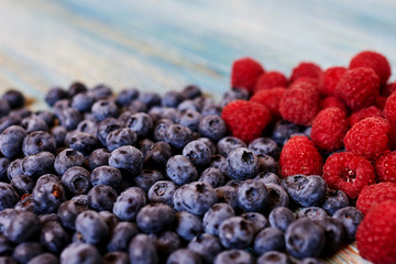 Blueberries with raspberries on a wooden table.