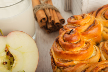Pie with apples and cinnamon on a wooden background with ingredients.