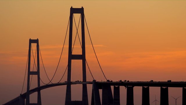 Vehicles Crossing the Great Belt Bridge at Sun Down