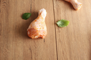 Chicken drumstick in marinade on a wooden background