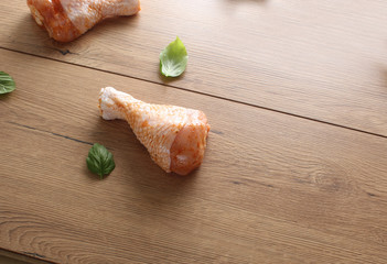 Chicken drumstick in marinade on a wooden background