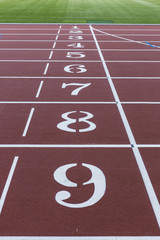 Red sport track for running on stadium with track numbers. Running healthy lifestyle concept. Sports background abstract texture