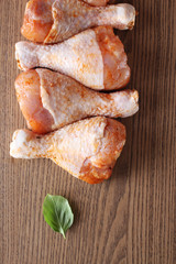 Chicken drumstick in marinade on a wooden background