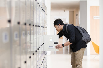 Student opening his locker at college