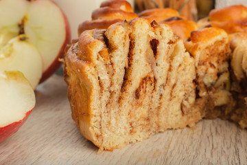 Pie with apples and cinnamon on a wooden background with ingredients.