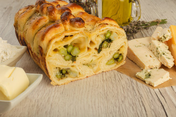 Pie with asparagus and cheese on a wooden background with ingredients.