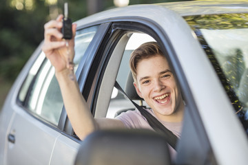 Happy learner driver cheering and holding car key