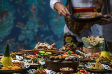 Waiter is serving table with different dishes. Waiter carrying plates with on some festive event or party