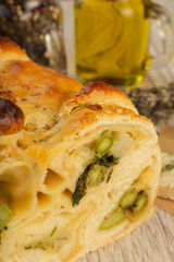 Pie with asparagus and cheese on a wooden background with ingredients.