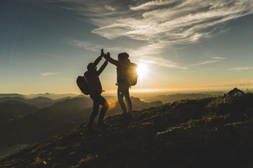 Austria, Salzkammergut, Cheering couple reaching mountain summit