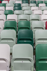 Fototapeta premium Rows of empty chairs on tribunes of a modern stadium without spectators and colored chairs with numbers in the center of the arena