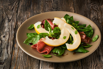 Concept of italian food with melon and prosciutto