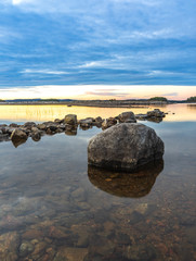 Fels im ruhiger Seenlandschaft in Schweden