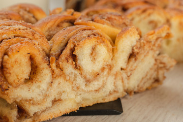 Pie with cinnamon and sugar on a wooden background.