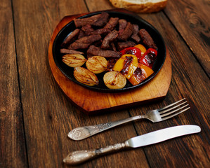 Cook served a delicious and hearty meal, for two persons, meat fried in the oven with onions and peppers coarsely chopped