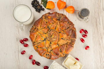 Cake with poppy seeds on a wooden background and ingredients.