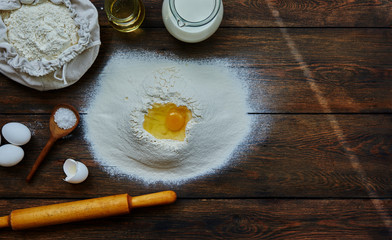Fototapeta na wymiar Healthy baking ingredients. Dough recipe ingredients. Flour, sugar, egg, butter on vintage wood table. Ingredients and kitchen items for baking cakes. Top view. Rustic background with text space.
