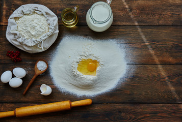 Fototapeta na wymiar Healthy baking ingredients. Dough recipe ingredients. Flour, sugar, egg, butter on vintage wood table. Ingredients and kitchen items for baking cakes. Top view. Rustic background with text space.