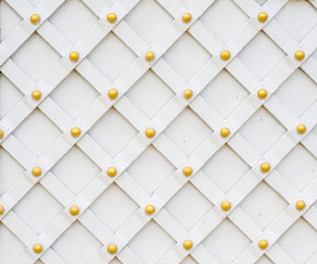 Forged gate background, grille with gold rivets, painted white color