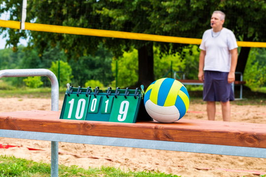 Volleyball ball and as a result  table with a coach in the background