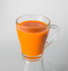 A glass of carrot juice on a white background