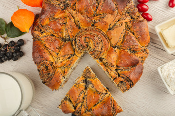 Cake with poppy seeds on a wooden background and ingredients.