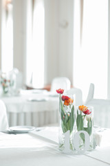 The wedding table is decorated with vases of red and orange talpans and number 10