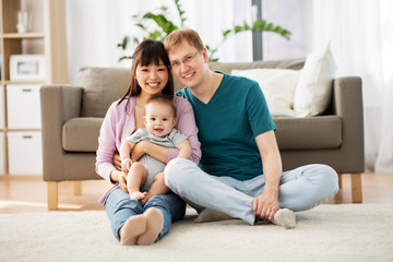 family, parenthood and people concept - happy mother and father with baby boy at home