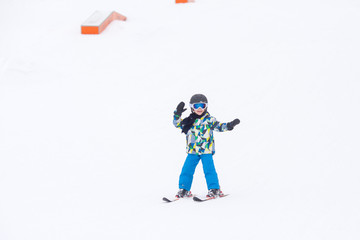 Fototapeta na wymiar Cute preschool child, boy, skiing happily in aAustrian ski resort, wintertime