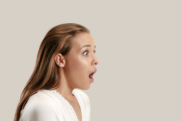 Wow. Beautiful female half-length profile portrait isolated on gray studio backgroud. Young...