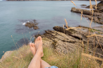 Children, enjoying quiet cloudy day on the ocean shore on the cliff, rocky beach
