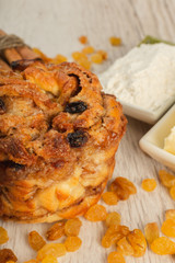 Pie with raisins and cinnamon on a wooden background with ingredients.