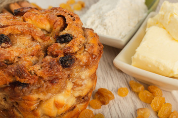 Pie with raisins and cinnamon on a wooden background with ingredients.