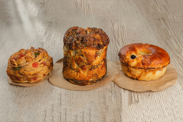 Three different pies on a wooden background.