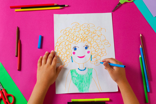 Child draws picture of mom for mother's day. Little girl made a drawing with pencil and marker.