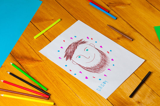 Child draws a portrait of his dad on christmas. The little boy did the drawing with pencil and marker on father's day.