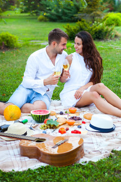 Love couple on Summer Picnic Basket on the Green Grass. Food and drink concept. Friends Party time