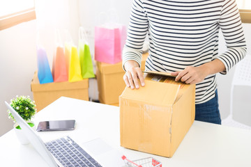 e-commerce delivery concept and online selling start up small business owner packing in the card box at workplace. freelance woman seller prepare product for packaging process at shop