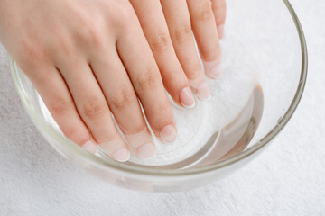 Warm bath for nails and dry skin. Mix of water and oil to soften cuticle. Proper care for hands.